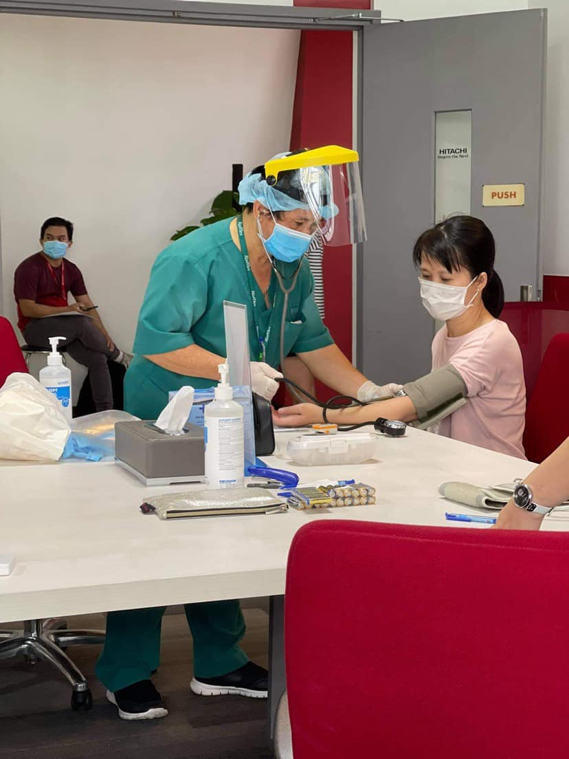 Tại tòa nhà Helios: Các nhân viên y tế đang khám sàng lọc trước tiêm cho nhân viên công ty Hitachi Vantara Vietnam