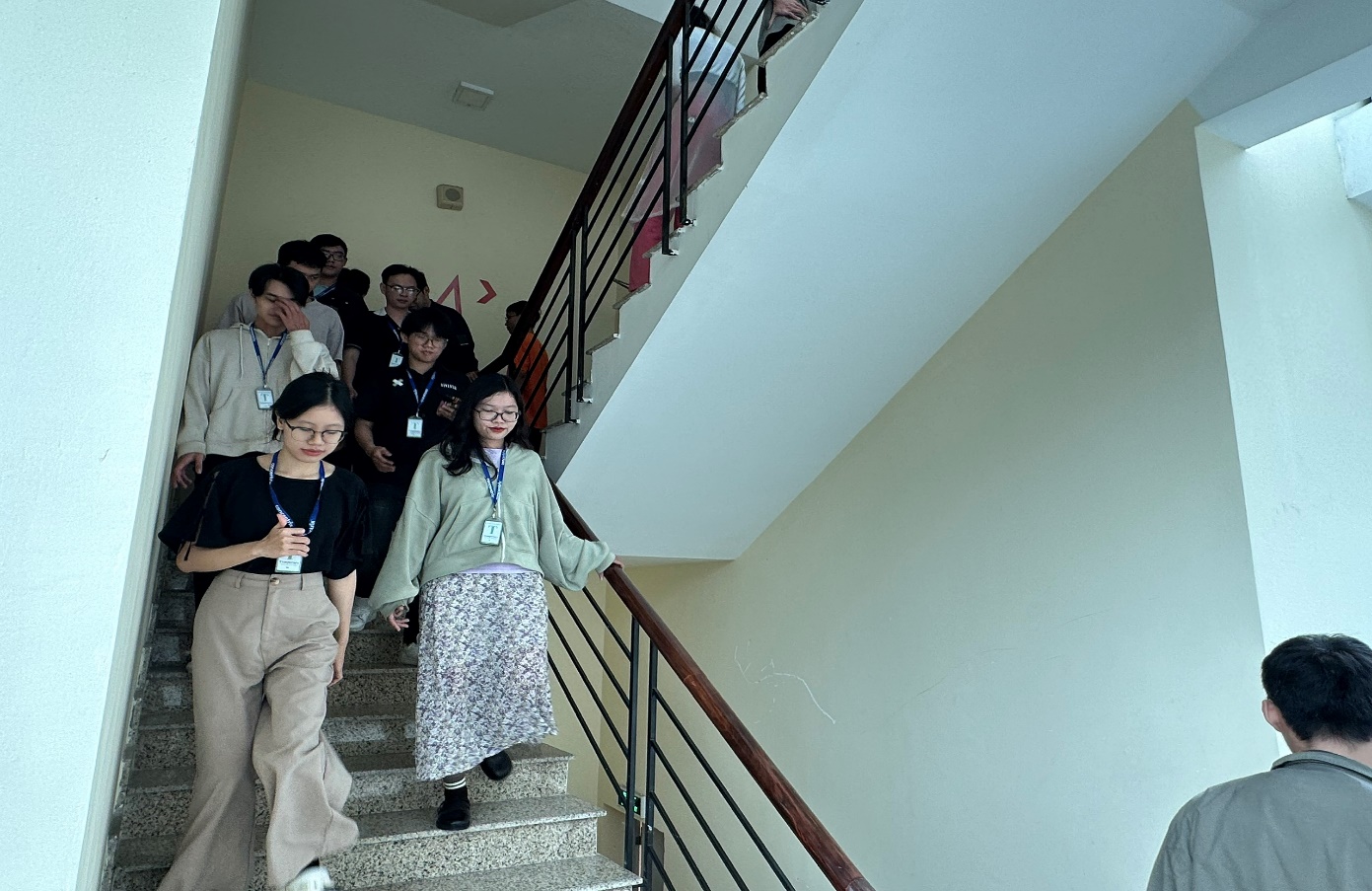 Employees evacuating via stairways to the designated assembly point outside the building